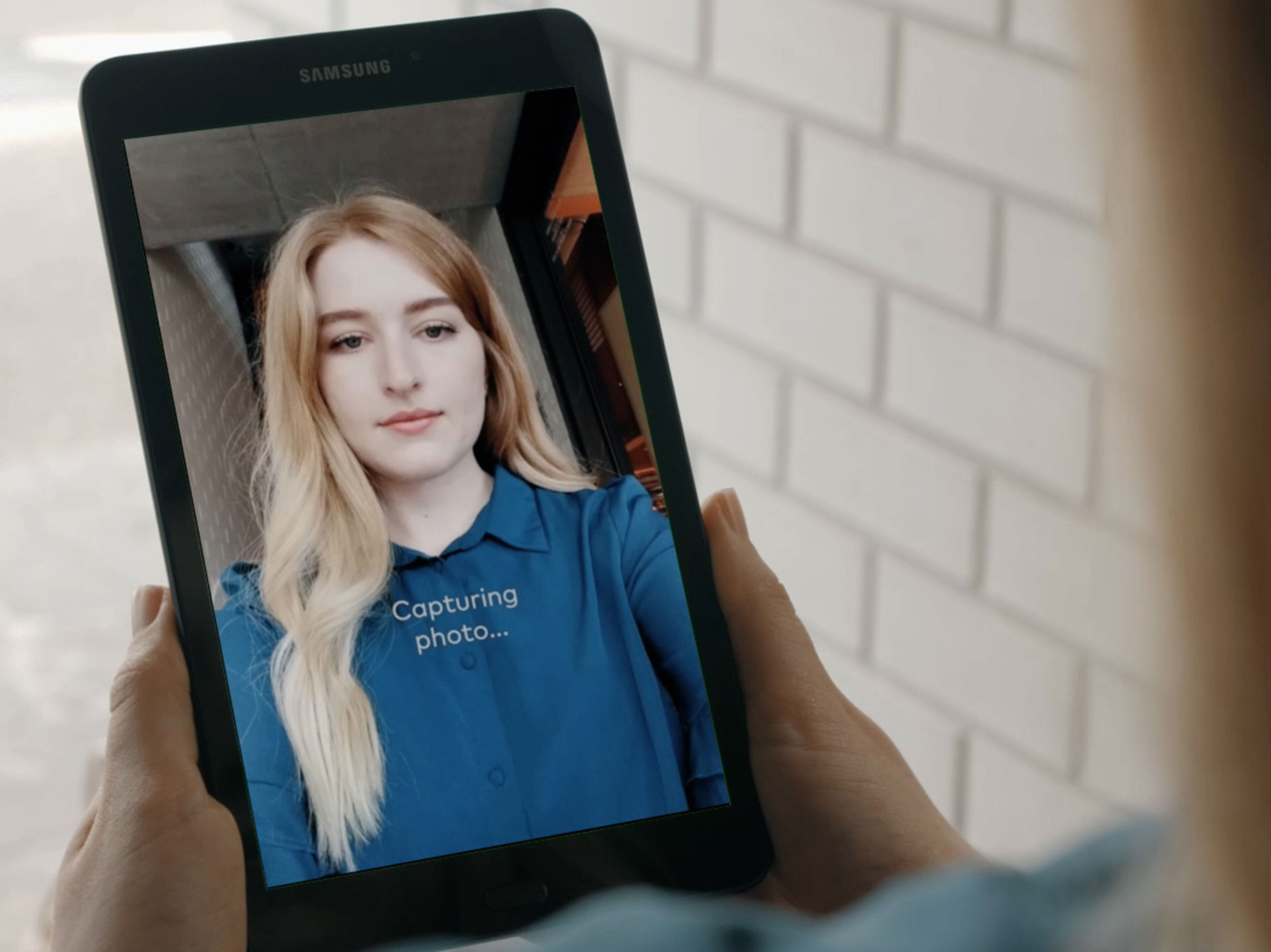 Tablet showing an app capturing a photograph of the user